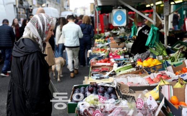 지난달 22일 한 여성이 영국 런던의 포토벨로 마켓에서 과일과 채소를 구매하고 있다. (사진/신화통신)